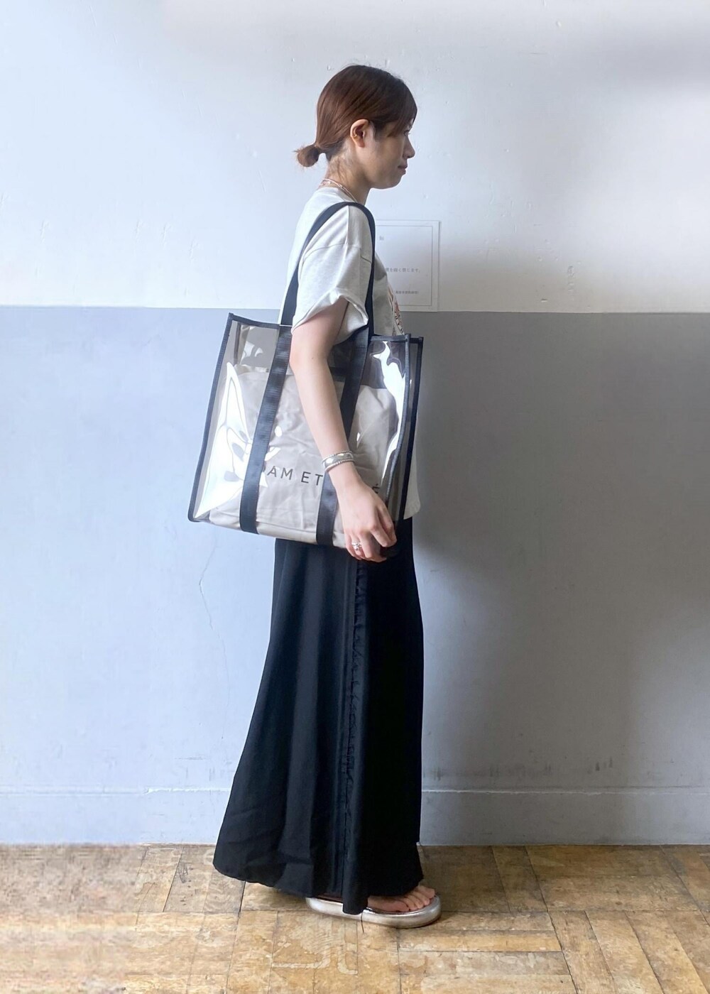 シルバー系のサンダル、ブラック系のトートバッグ、グレー系のTシャツ/カットソーを着用したレディースの夏コーディネートの4枚目の写真