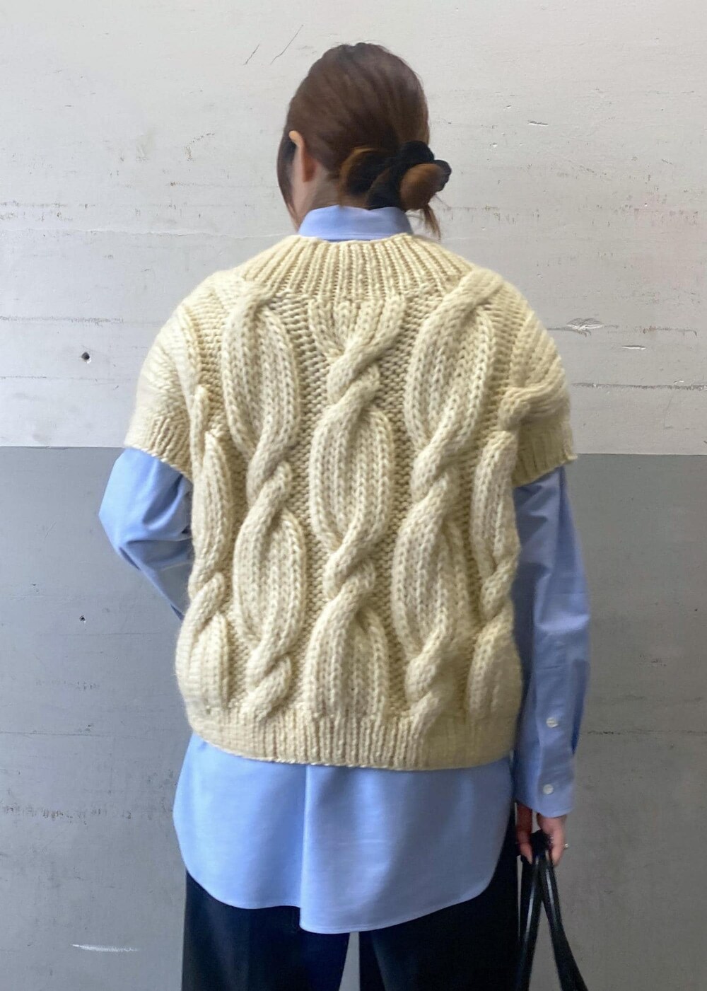 ホワイト系のニット/セーター、ブラック系のボストンバッグ、ブルー系のシャツ/ブラウスを着用したレディースの秋コーディネートの6枚目の写真