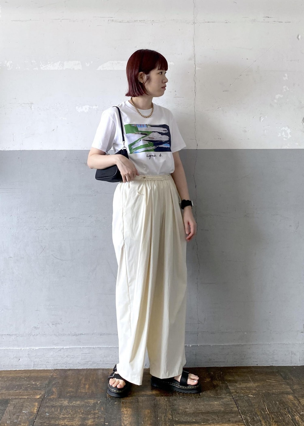 ブラック系のショルダーバッグ、ホワイト系のTシャツ/カットソーを着用したレディースの夏コーディネートの2枚目の写真