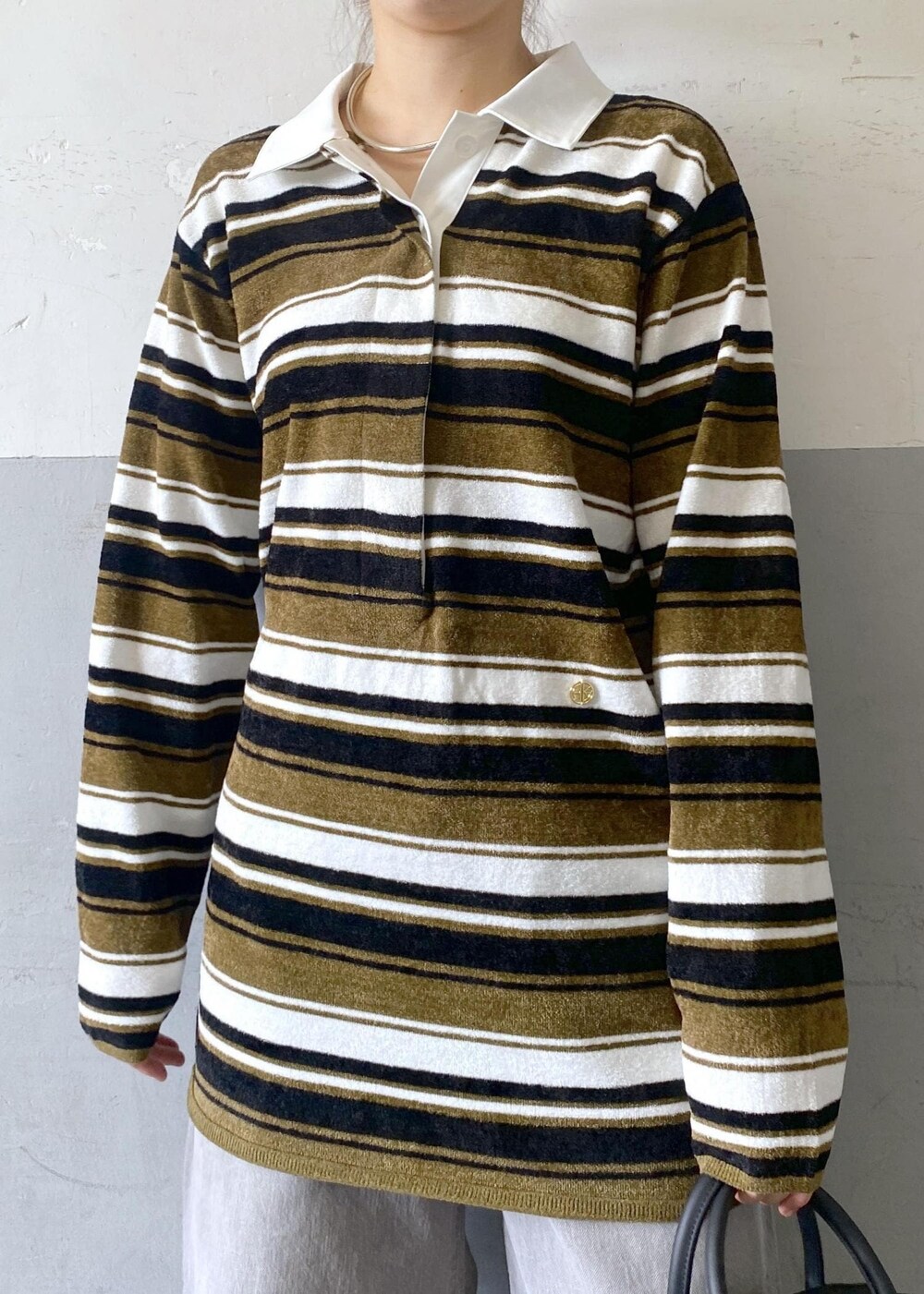 ブラック系のブーツ、ブラック系のボストンバッグ、グリーン系のワンピースを着用したレディースの秋コーディネートの10枚目の写真