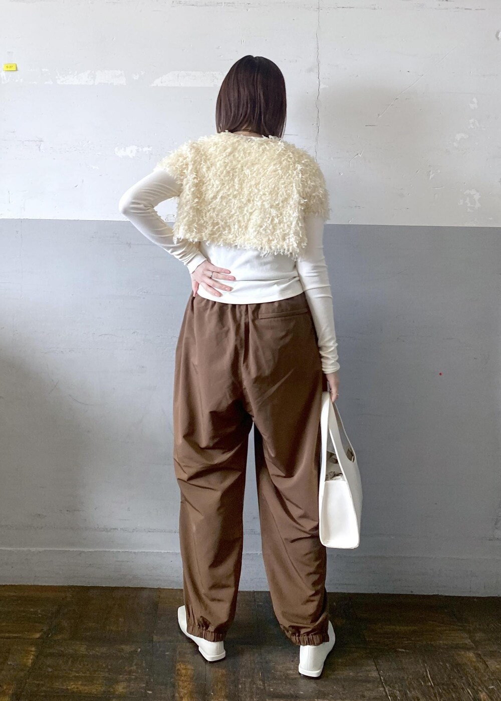 ホワイト系のハンドバッグを着用したレディースの冬コーディネートの4枚目の写真