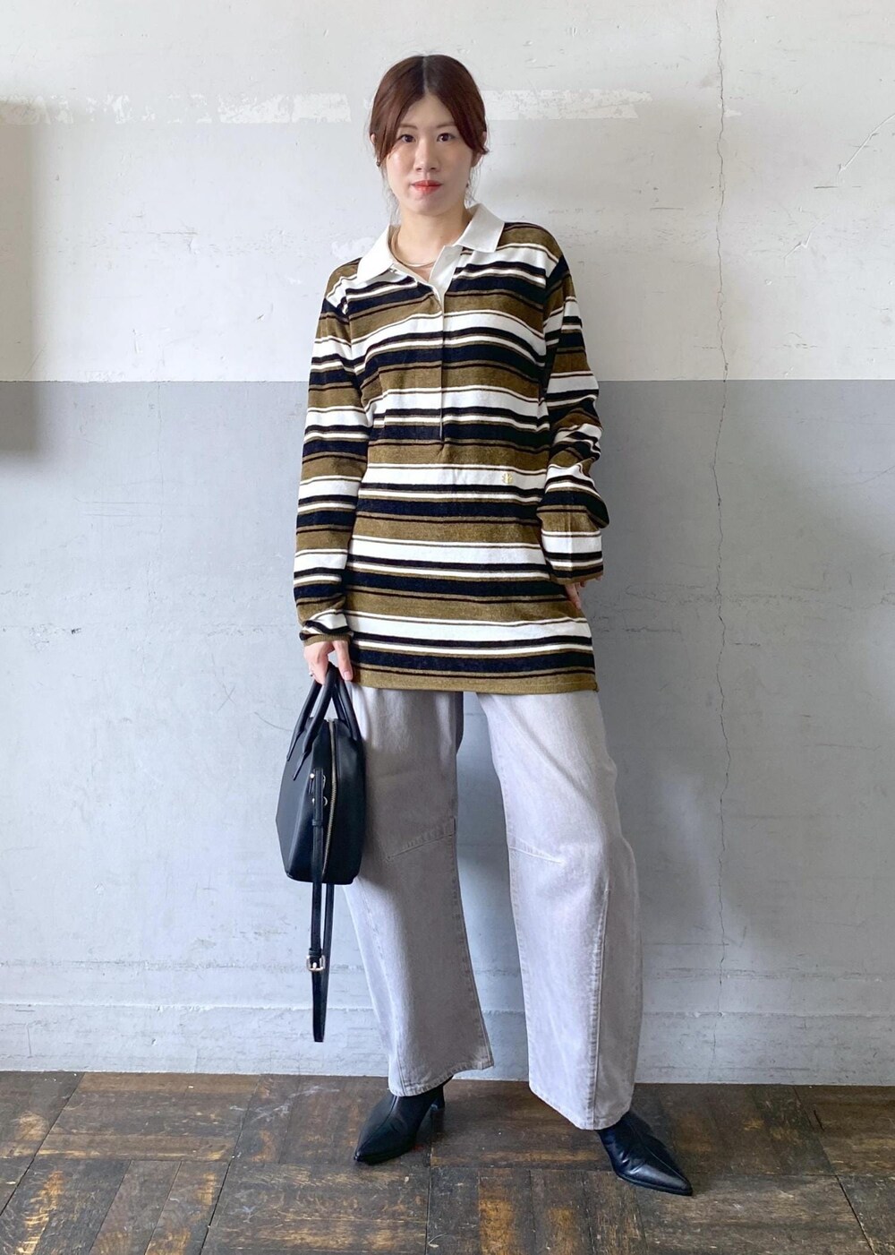 ブラック系のブーツ、ブラック系のボストンバッグ、グリーン系のワンピースを着用したレディースの秋コーディネートの7枚目の写真