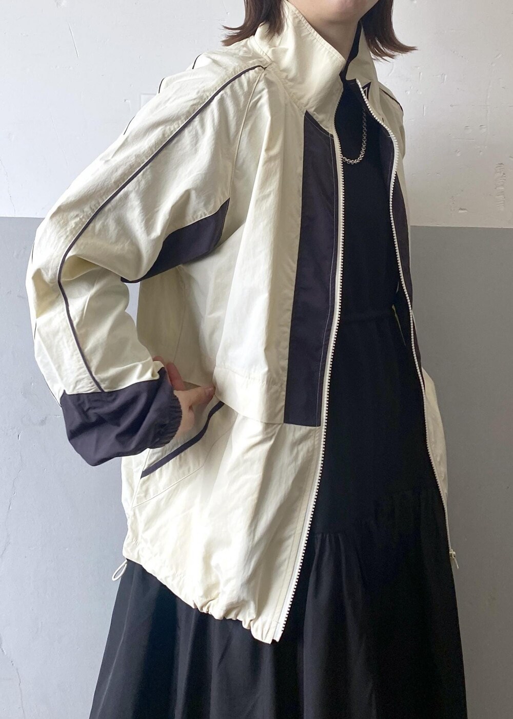 シルバー系のショルダーバッグ、ホワイト系のその他アウター、ブラック系のワンピースを着用したレディースの冬コーディネートの6枚目の写真