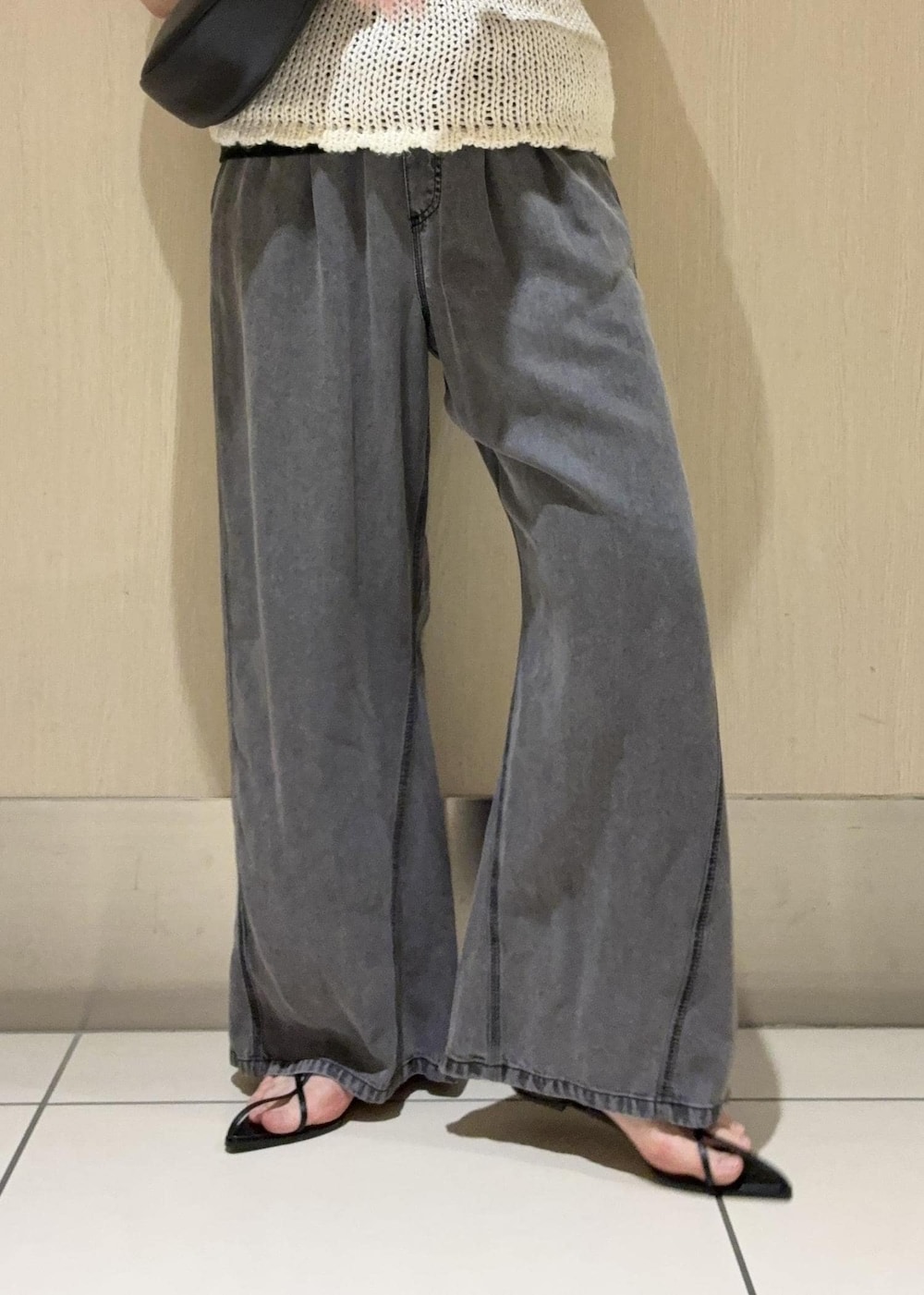 ブラック系のデニムパンツ、ブラック系のショルダーバッグ、ホワイト系のタンクトップを着用したレディースの春コーディネートの8枚目の写真