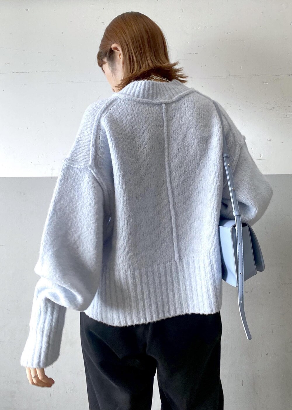 ブルー系のニット/セーター、ブラック系のその他パンツ、ブルー系のショルダーバッグを着用したレディースの秋コーディネートの6枚目の写真
