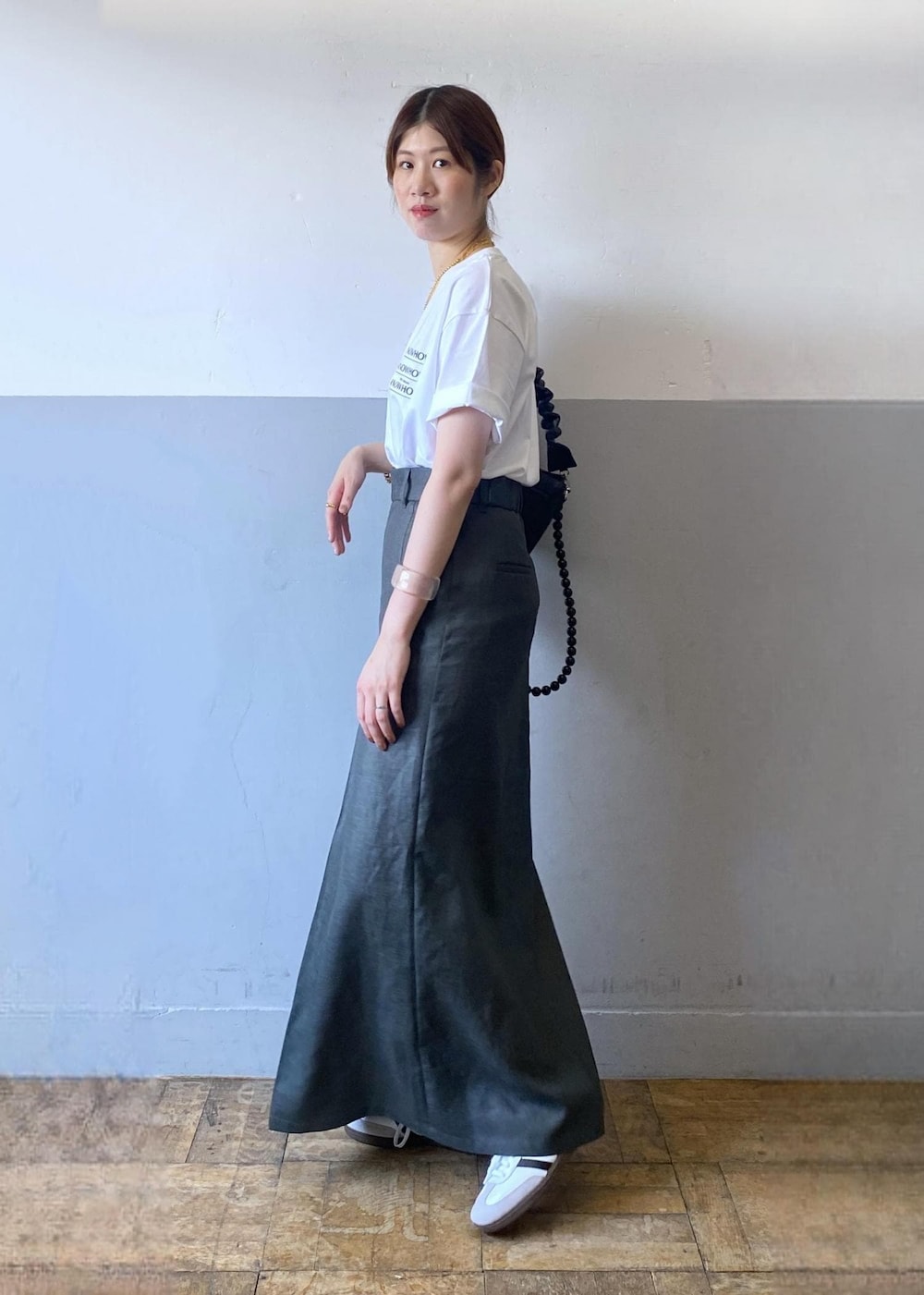 グレー系のスカート、ブラック系のショルダーバッグ、ホワイト系のTシャツ/カットソーを着用したレディースの夏コーディネートの4枚目の写真