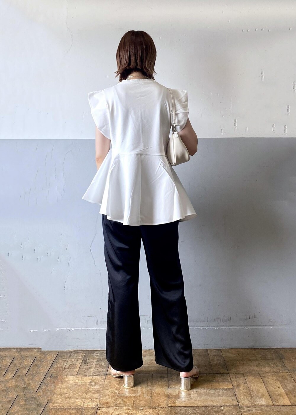 ホワイト系のショルダーバッグ、ブラック系のその他パンツ、ホワイト系のTシャツ/カットソーを着用したレディースの夏コーディネートの3枚目の写真