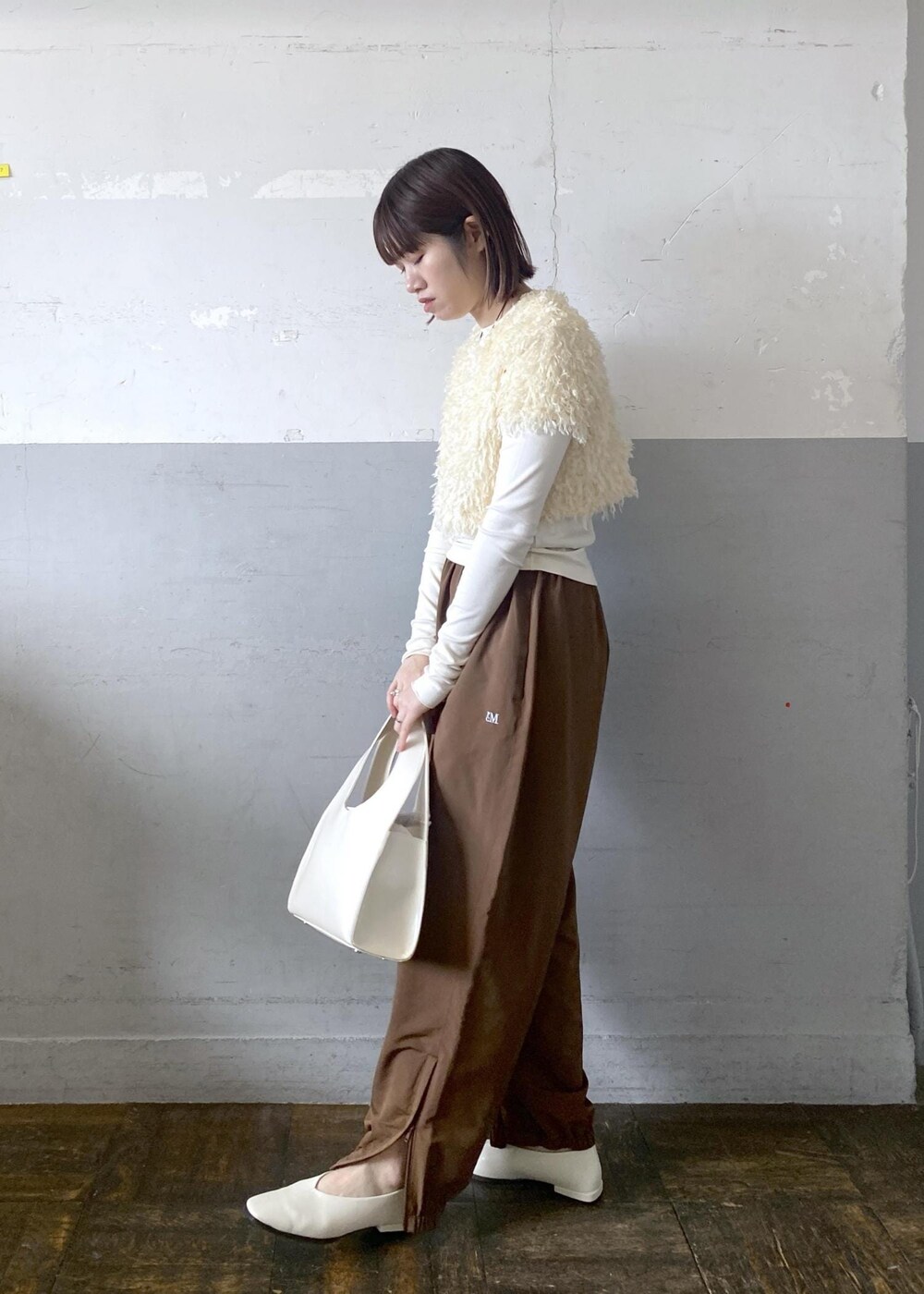 ホワイト系のハンドバッグを着用したレディースの冬コーディネートの3枚目の写真