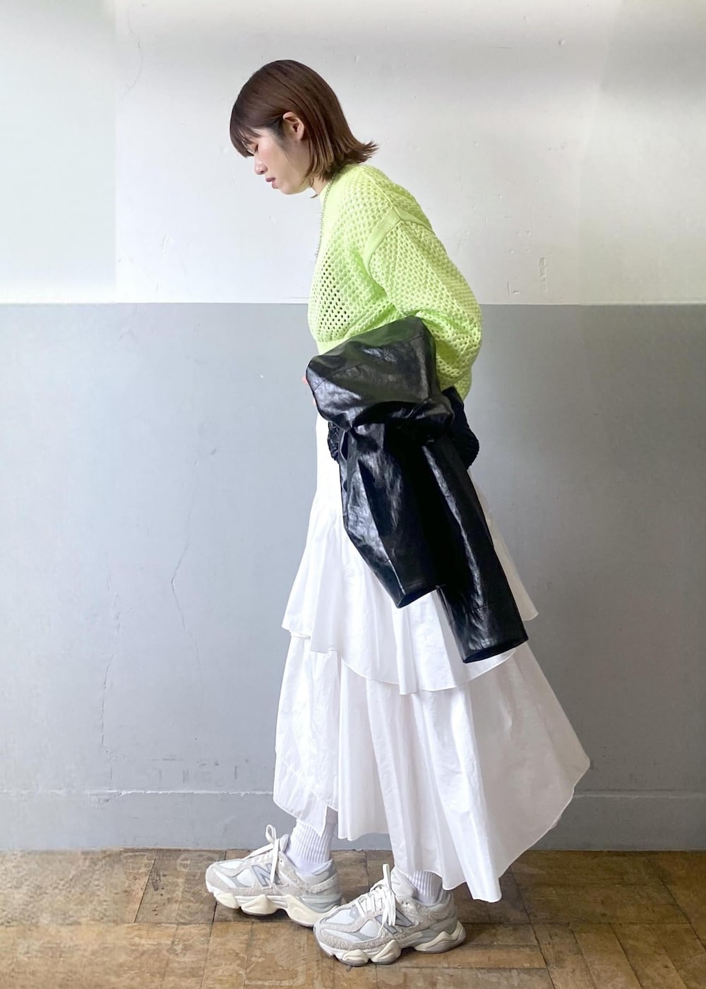 ホワイト系のスカート、ブラック系のブルゾン、グリーン系のニット/セーターを着用したレディースの春コーディネートの3枚目の写真