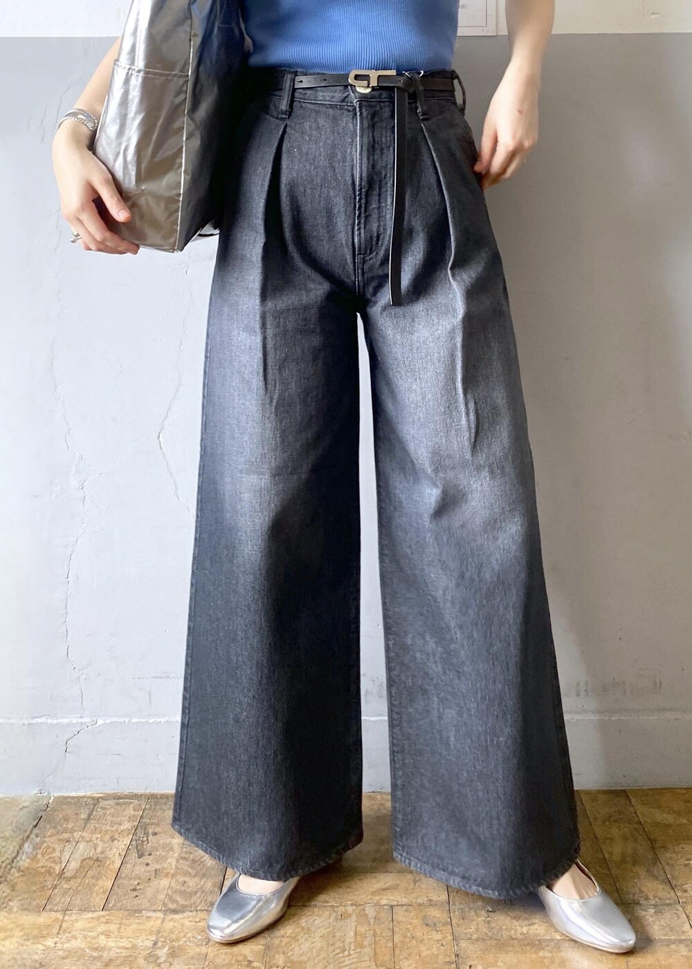 シルバー系のパンプス、ブラック系のデニムパンツ、ブラック系のトートバッグを着用したレディースの春コーディネートの5枚目の写真