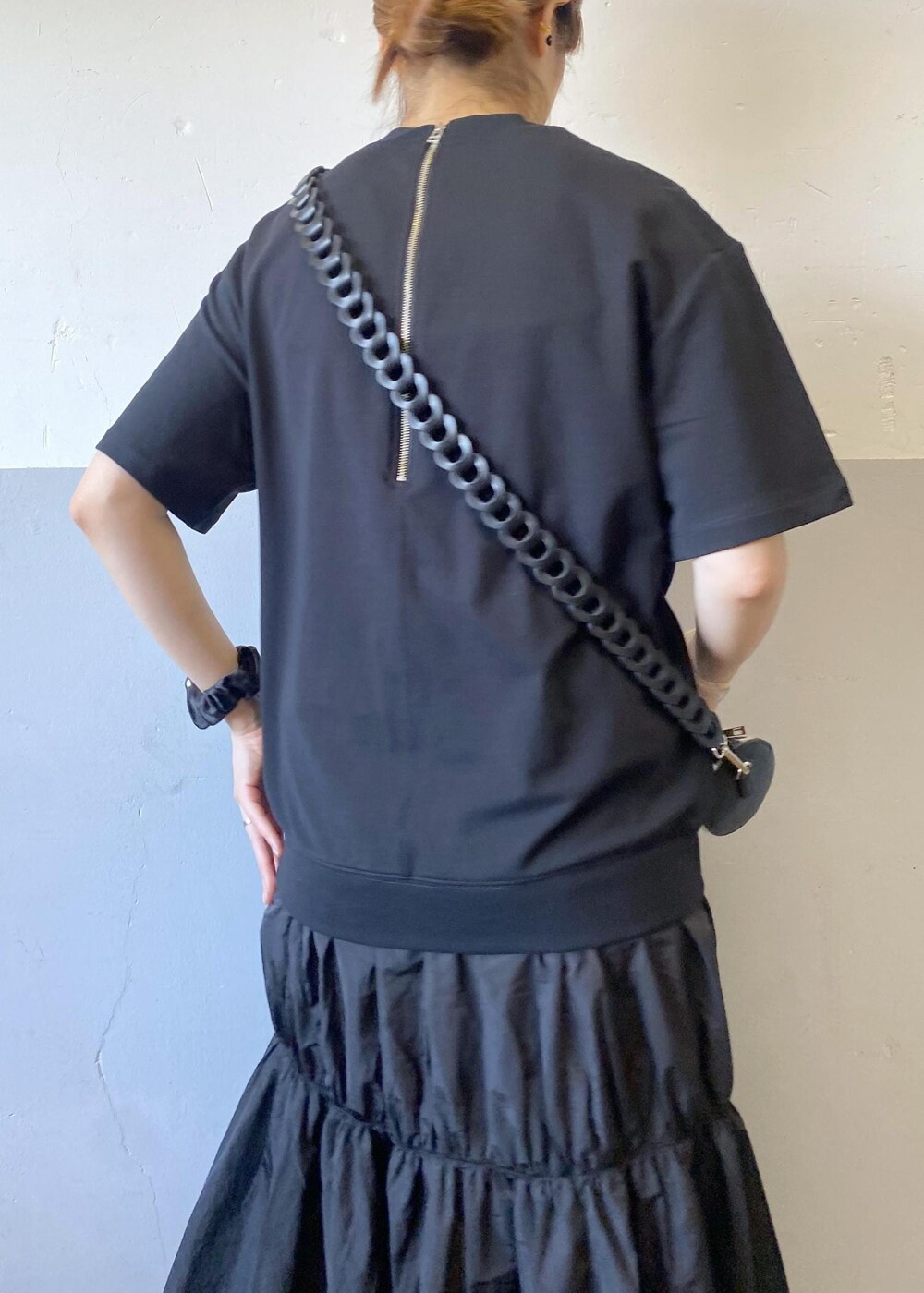 ブラック系のスニーカー、ブラック系のドラムバッグ、ブラック系のワンピースを着用したレディースの夏コーディネートの8枚目の写真