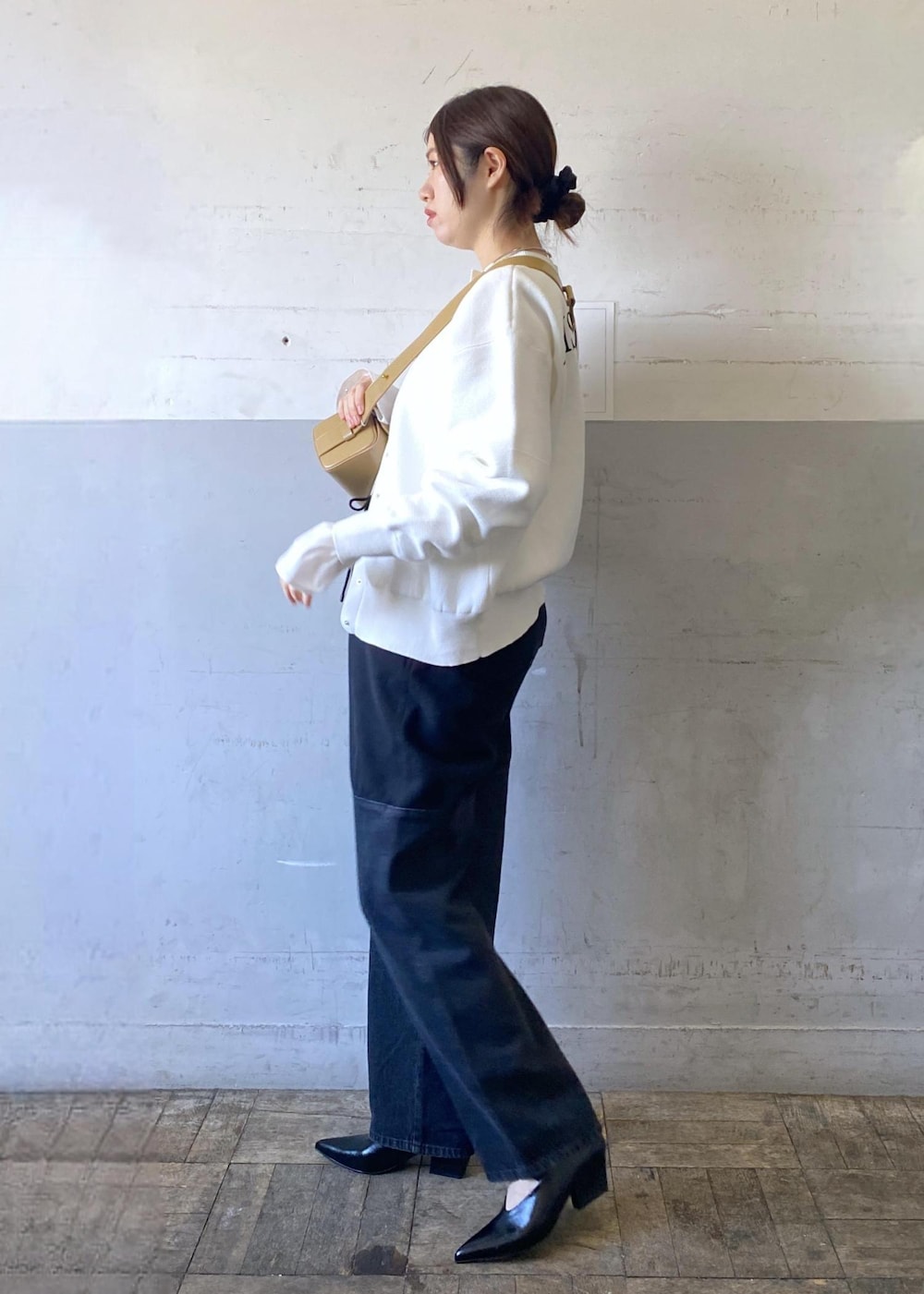 ベージュ系のハンドバッグ、ブラック系のパンプス、ホワイト系のカーディガン/ボレロを着用したレディースの冬コーディネートの5枚目の写真