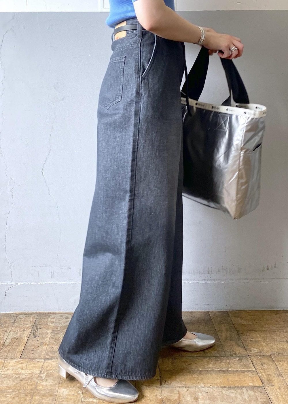 シルバー系のパンプス、ブラック系のデニムパンツ、ブラック系のトートバッグを着用したレディースの春コーディネートの6枚目の写真