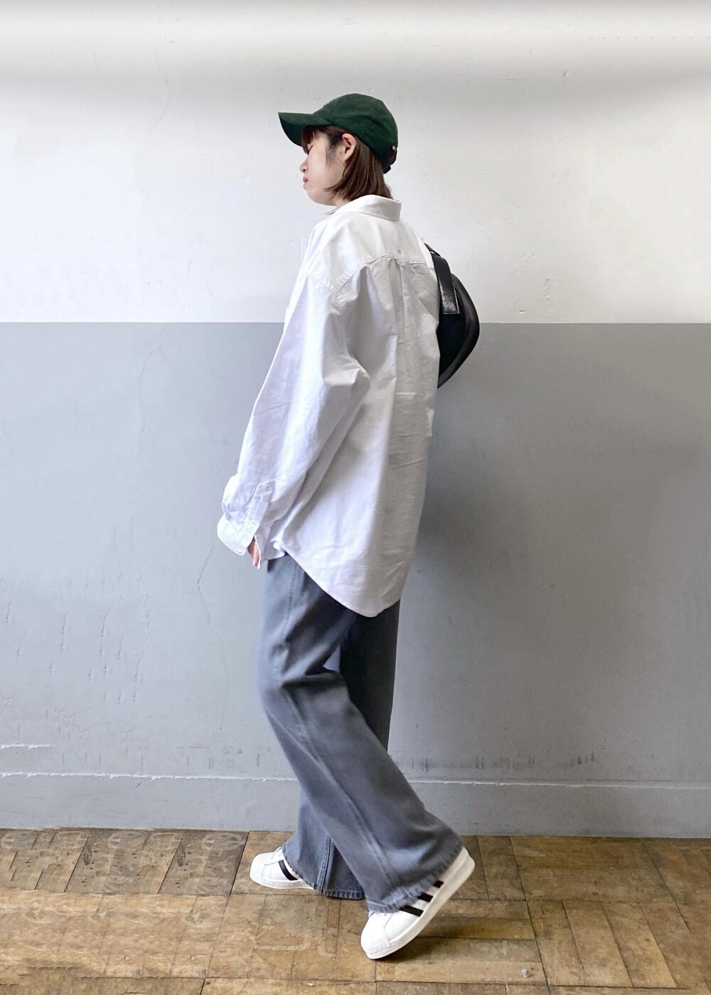 ブラック系のTシャツ/カットソー、ブラック系のショルダーバッグ、ホワイト系のシャツ/ブラウスを着用したレディースの冬コーディネートの3枚目の写真