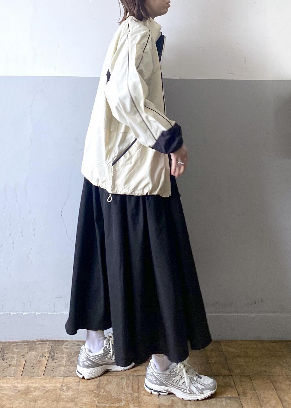 シルバー系のショルダーバッグ、ホワイト系のその他アウター、ブラック系のワンピースを着用したレディースの冬コーディネートの4枚目の写真