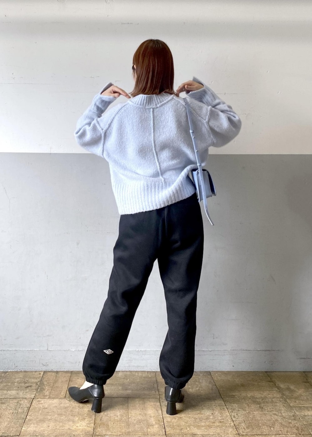 ブルー系のニット/セーター、ブラック系のその他パンツ、ブルー系のショルダーバッグを着用したレディースの秋コーディネートの3枚目の写真