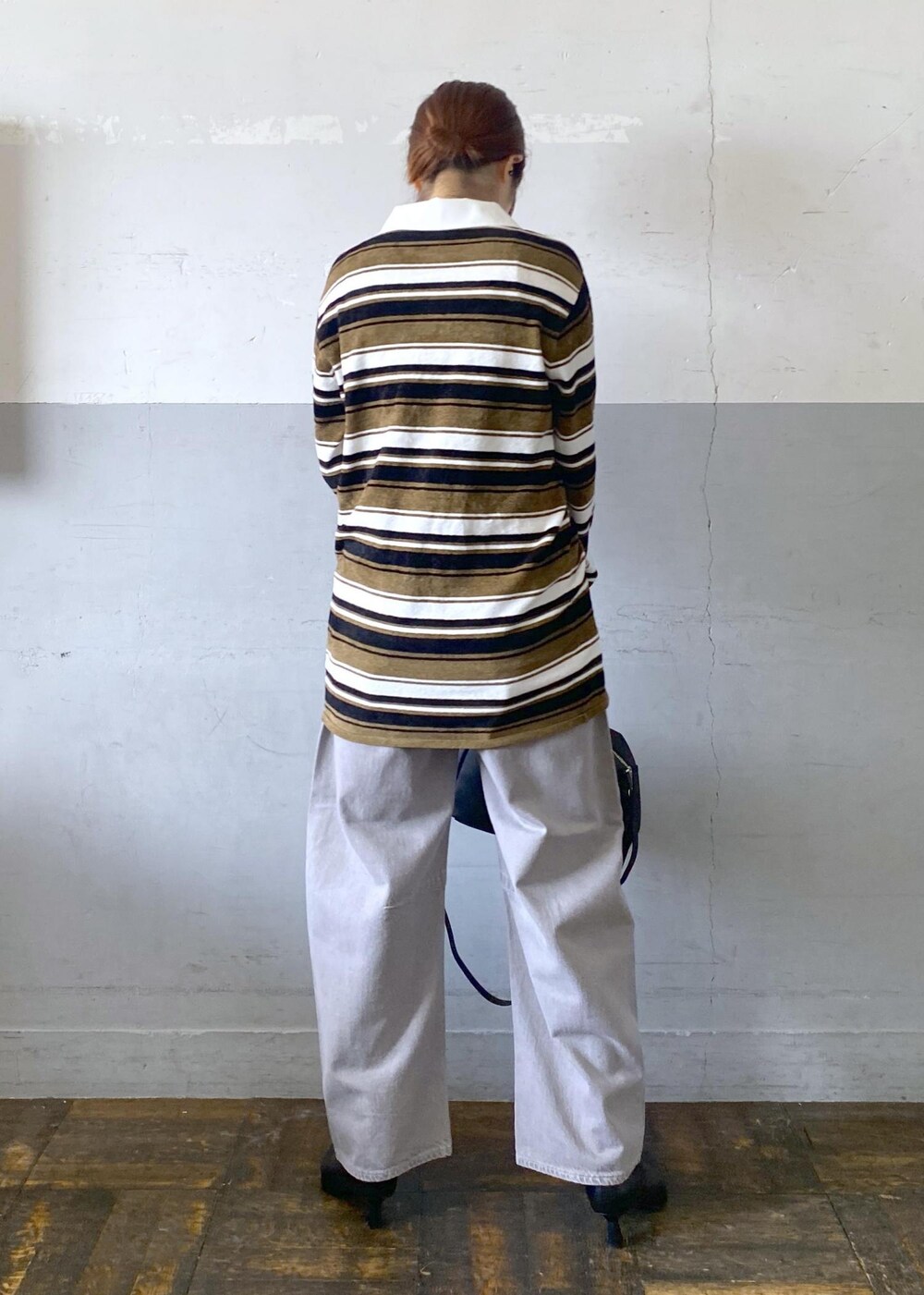 ブラック系のブーツ、ブラック系のボストンバッグ、グリーン系のワンピースを着用したレディースの秋コーディネートの2枚目の写真