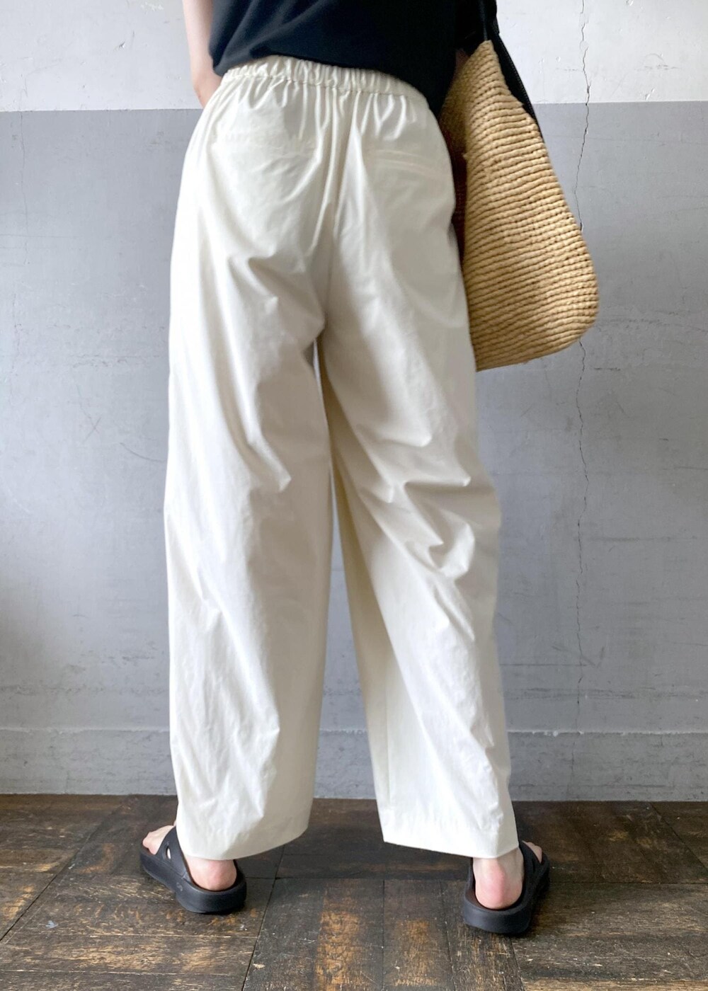 ベージュ系のトートバッグ、ブラック系のTシャツ/カットソー、ブラック系のサンダルを着用したレディースの夏コーディネートの9枚目の写真