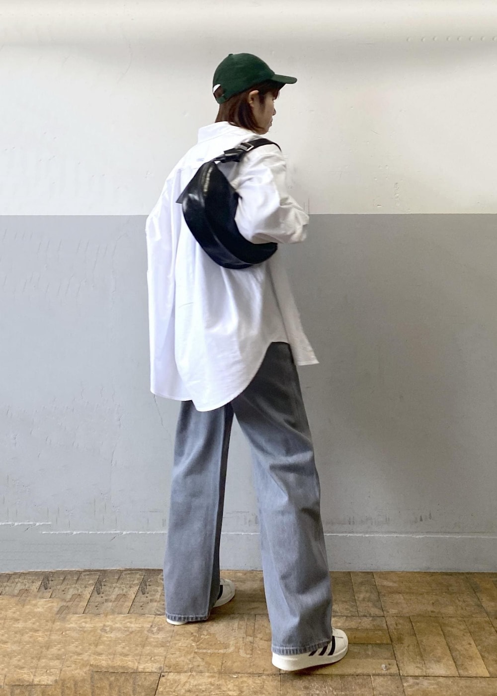 ブラック系のTシャツ/カットソー、ブラック系のショルダーバッグ、ホワイト系のシャツ/ブラウスを着用したレディースの冬コーディネートの2枚目の写真