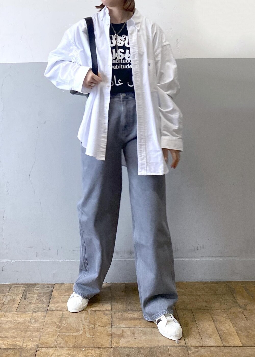 ブラック系のTシャツ/カットソー、ブラック系のショルダーバッグ、ホワイト系のシャツ/ブラウスを着用したレディースの冬コーディネートの7枚目の写真