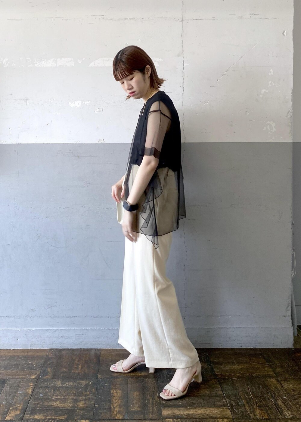 グレー系のショルダーバッグ、ベージュ系のサンダル、ベージュ系のスラックスを着用したレディースの夏コーディネートの5枚目の写真