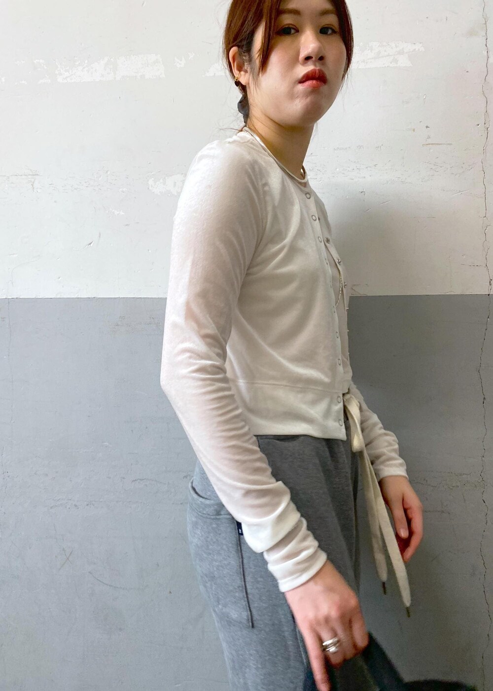 ブラック系のパンプス、ホワイト系のカーディガン/ボレロ、グレー系のスウェットパンツを着用したレディースの秋コーディネートの7枚目の写真