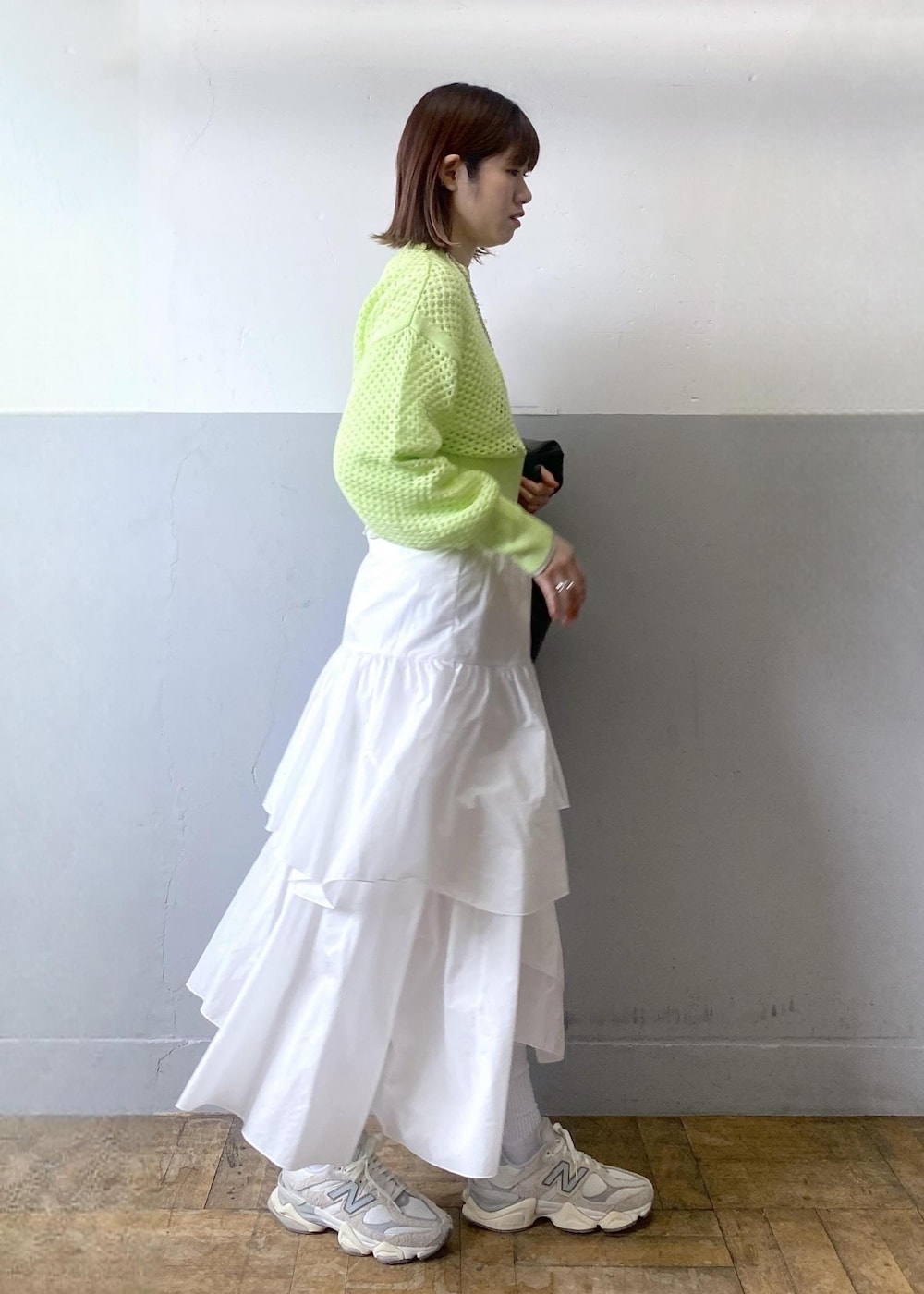 ホワイト系のスカート、ブラック系のブルゾン、グリーン系のニット/セーターを着用したレディースの春コーディネートの2枚目の写真