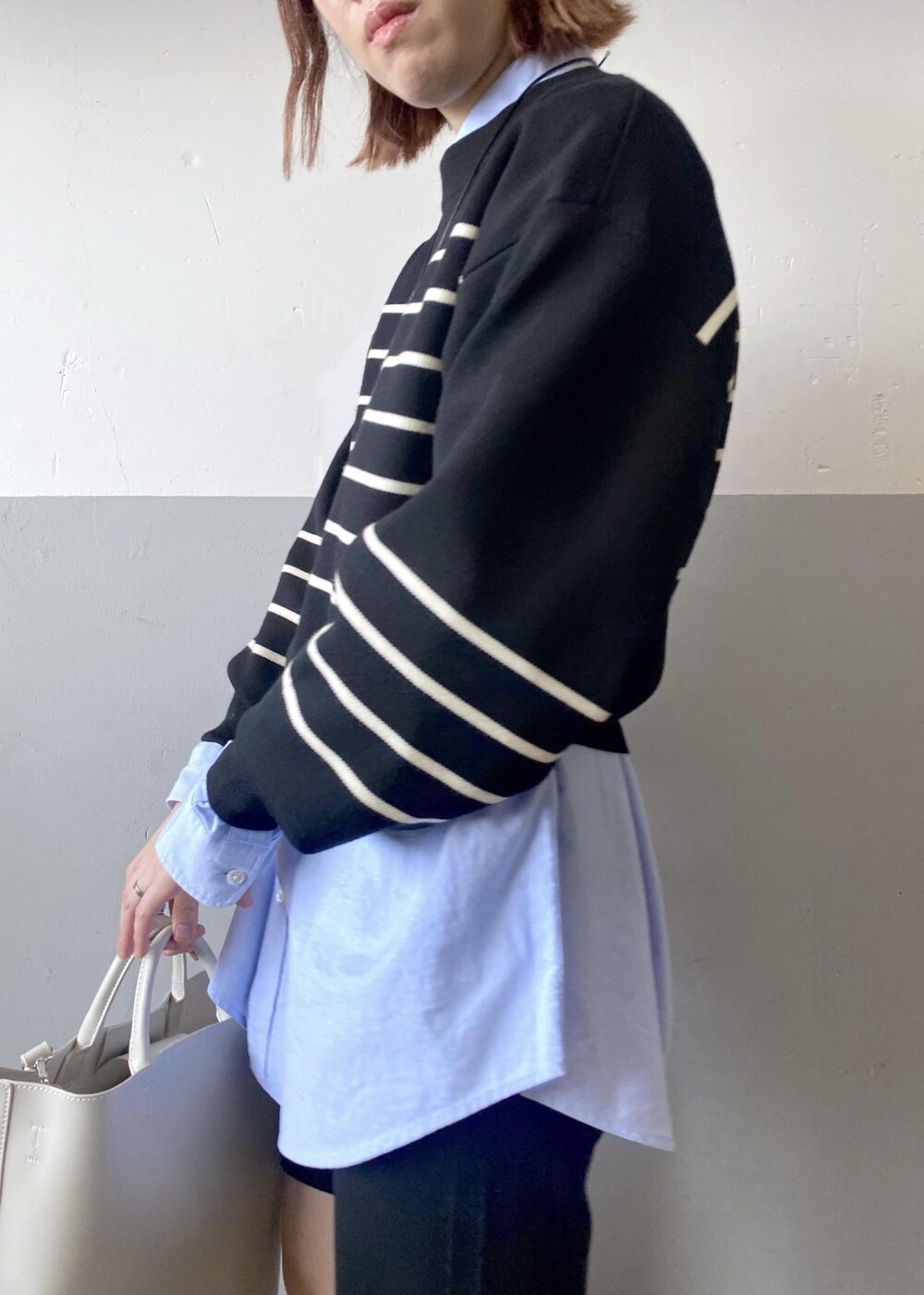 ホワイト系のトートバッグ、ブラック系のニット/セーター、ブルー系のシャツ/ブラウスを着用したレディースの秋コーディネートの7枚目の写真