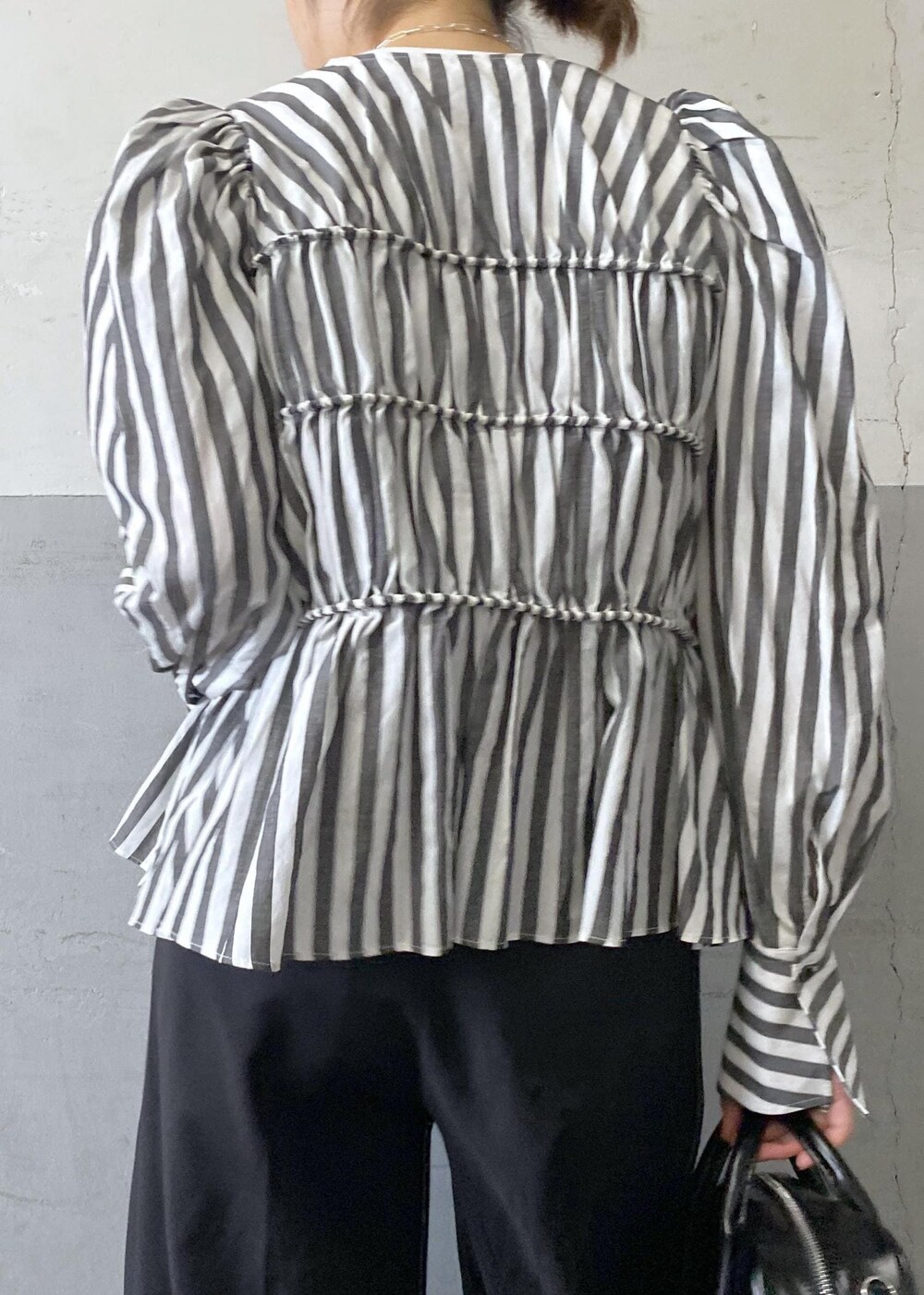 ホワイト系のシャツ/ブラウス、ブラック系のスラックス、ブラック系のボストンバッグを着用したレディースの春コーディネートの9枚目の写真