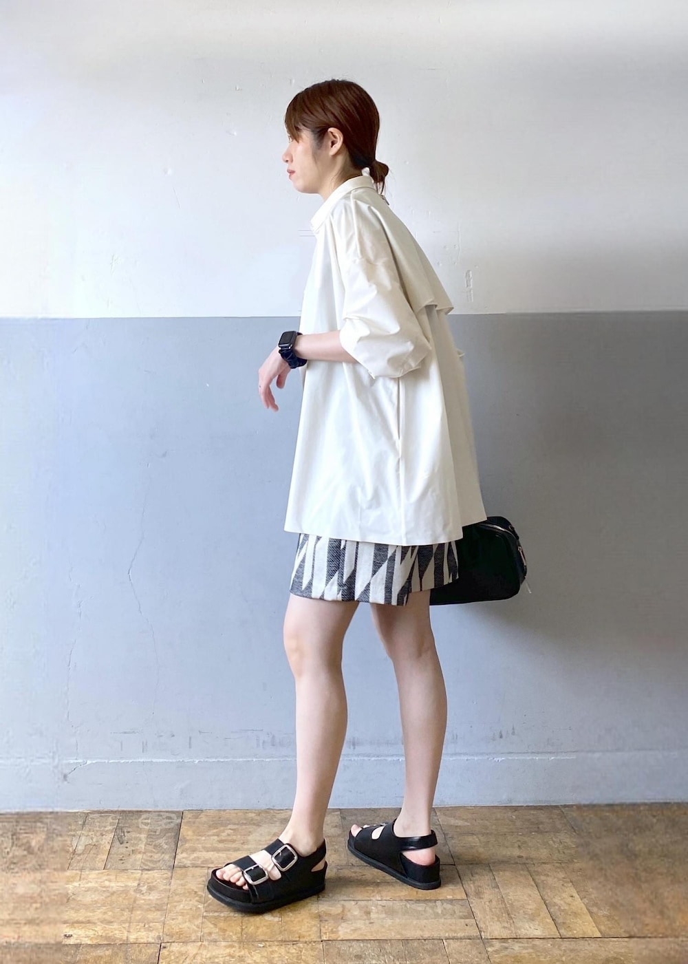 ブラック系のサンダル、ブラック系のボストンバッグ、ブラック系のタンクトップを着用したレディースの春コーディネートの4枚目の写真