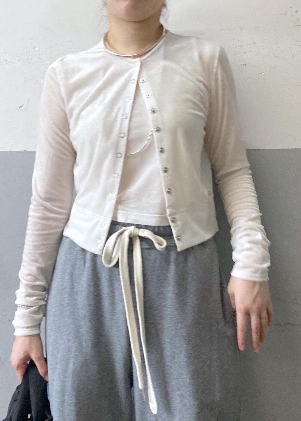ブラック系のパンプス、ホワイト系のカーディガン/ボレロ、グレー系のスウェットパンツを着用したレディースの秋コーディネートの9枚目の写真
