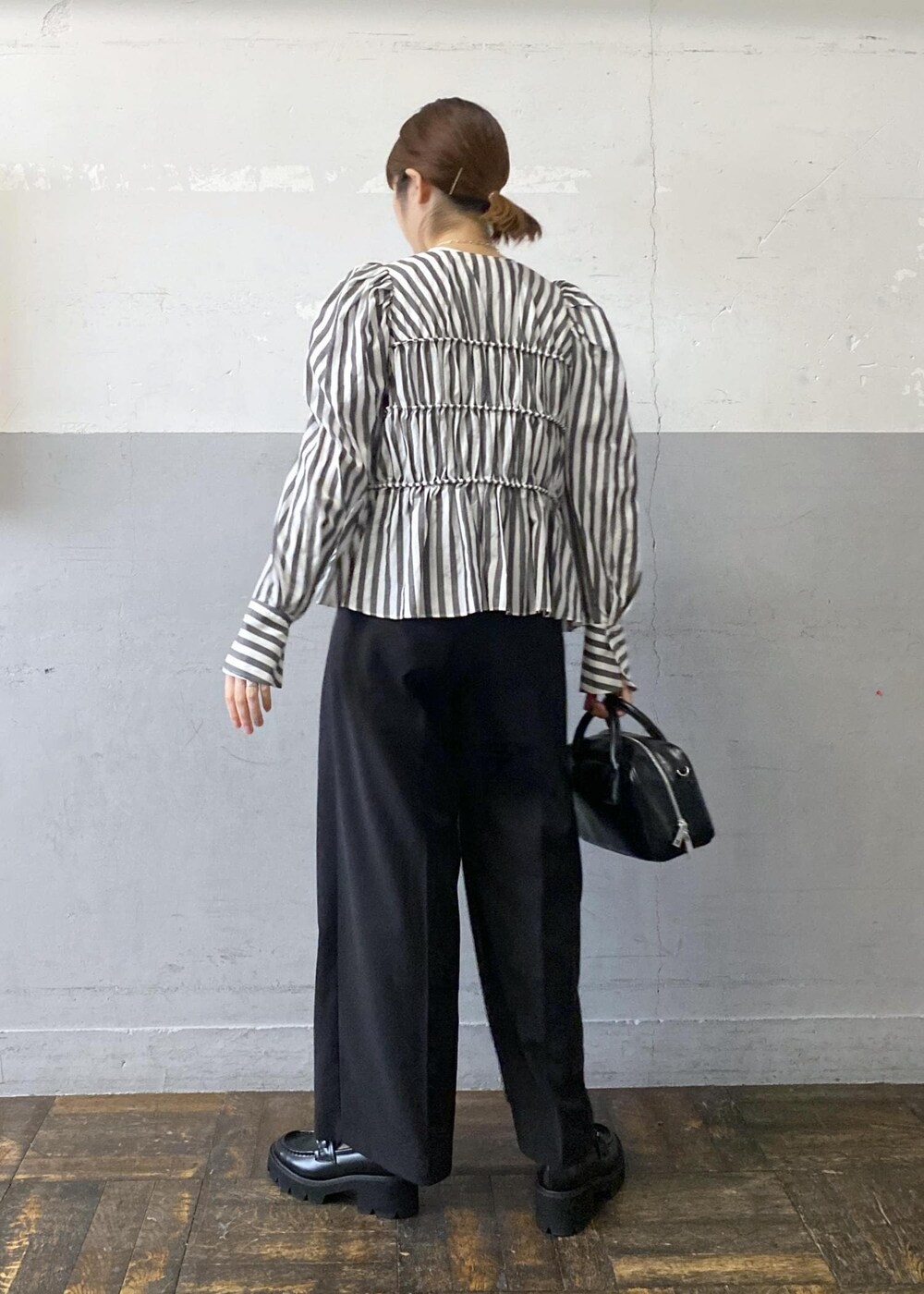 ホワイト系のシャツ/ブラウス、ブラック系のスラックス、ブラック系のボストンバッグを着用したレディースの春コーディネートの4枚目の写真