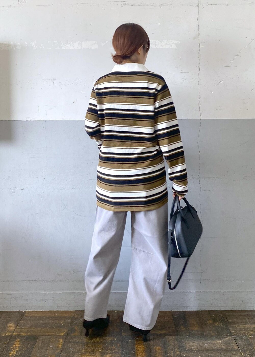 ブラック系のブーツ、ブラック系のボストンバッグ、グリーン系のワンピースを着用したレディースの秋コーディネートの3枚目の写真