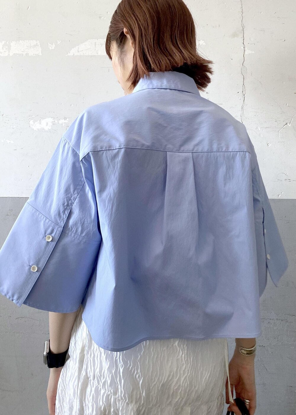 シルバー系のサンダル、ホワイト系のスカート、ブラック系のハンドバッグを着用したレディースの夏コーディネートの5枚目の写真