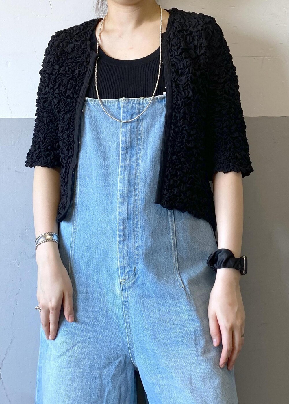 シルバー系のサンダル、ブルー系のサロペット/オーバーオール、ブラック系のカーディガン/ボレロを着用したレディースの春コーディネートの7枚目の写真