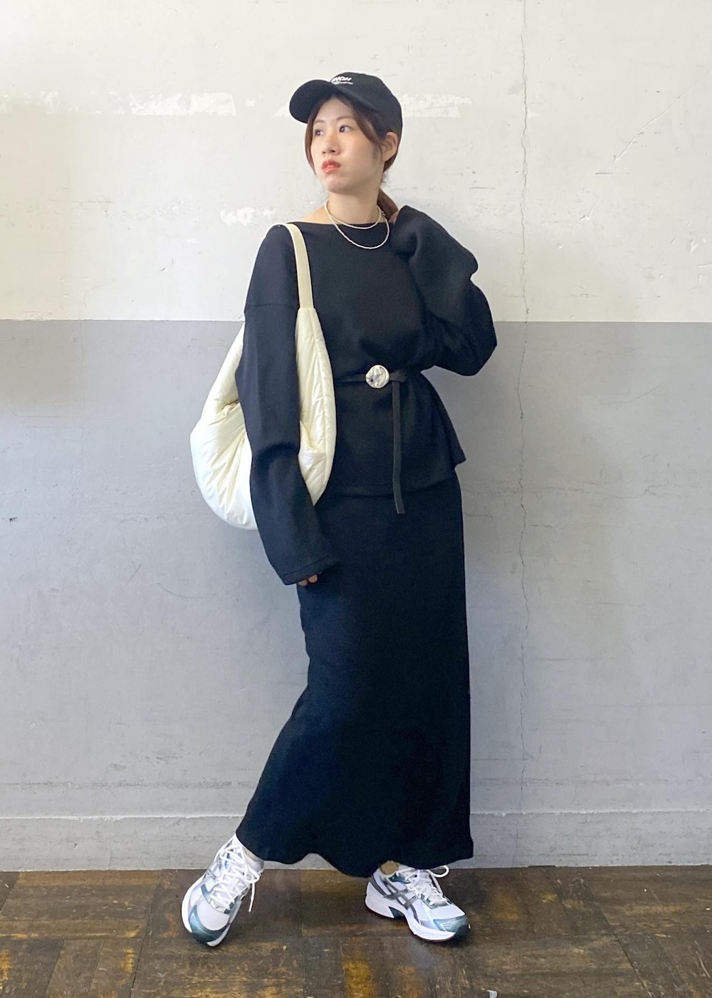 ホワイト系のショルダーバッグ、ブラック系のTシャツ/カットソー、ブラック系のスカートを着用したレディースの秋コーディネートの2枚目の写真