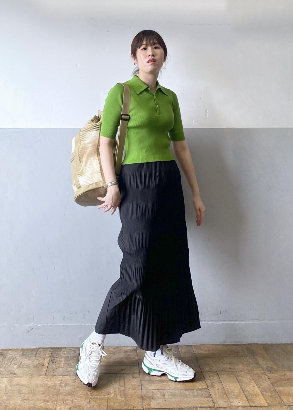 ホワイト系のスニーカー、ブラック系のスカートを着用したレディースの春コーディネートの2枚目の写真