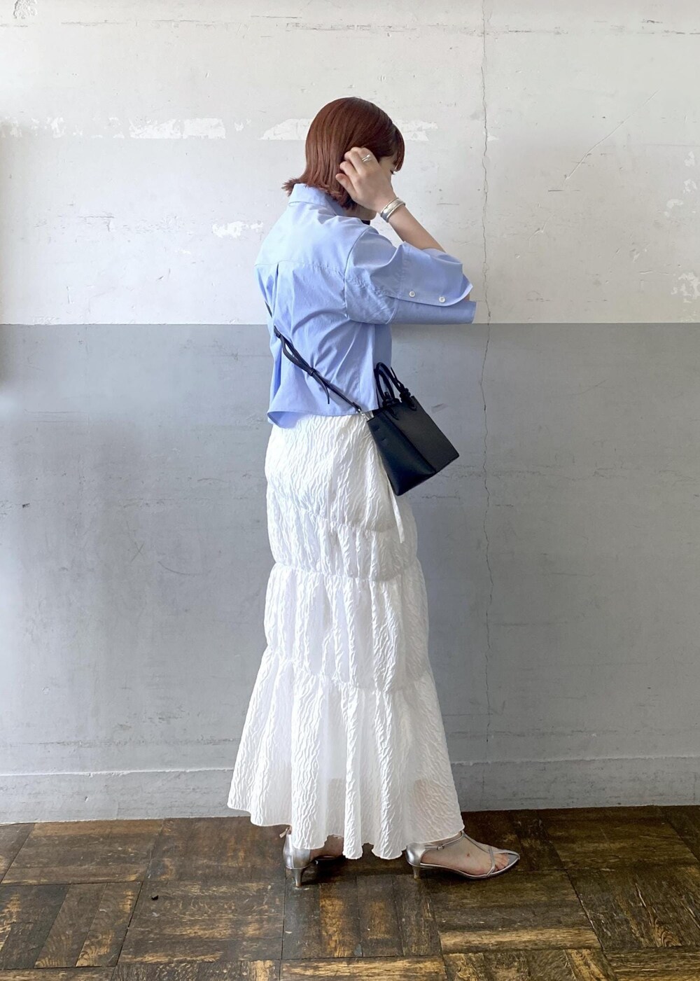 シルバー系のサンダル、ホワイト系のスカート、ブラック系のハンドバッグを着用したレディースの夏コーディネートの4枚目の写真