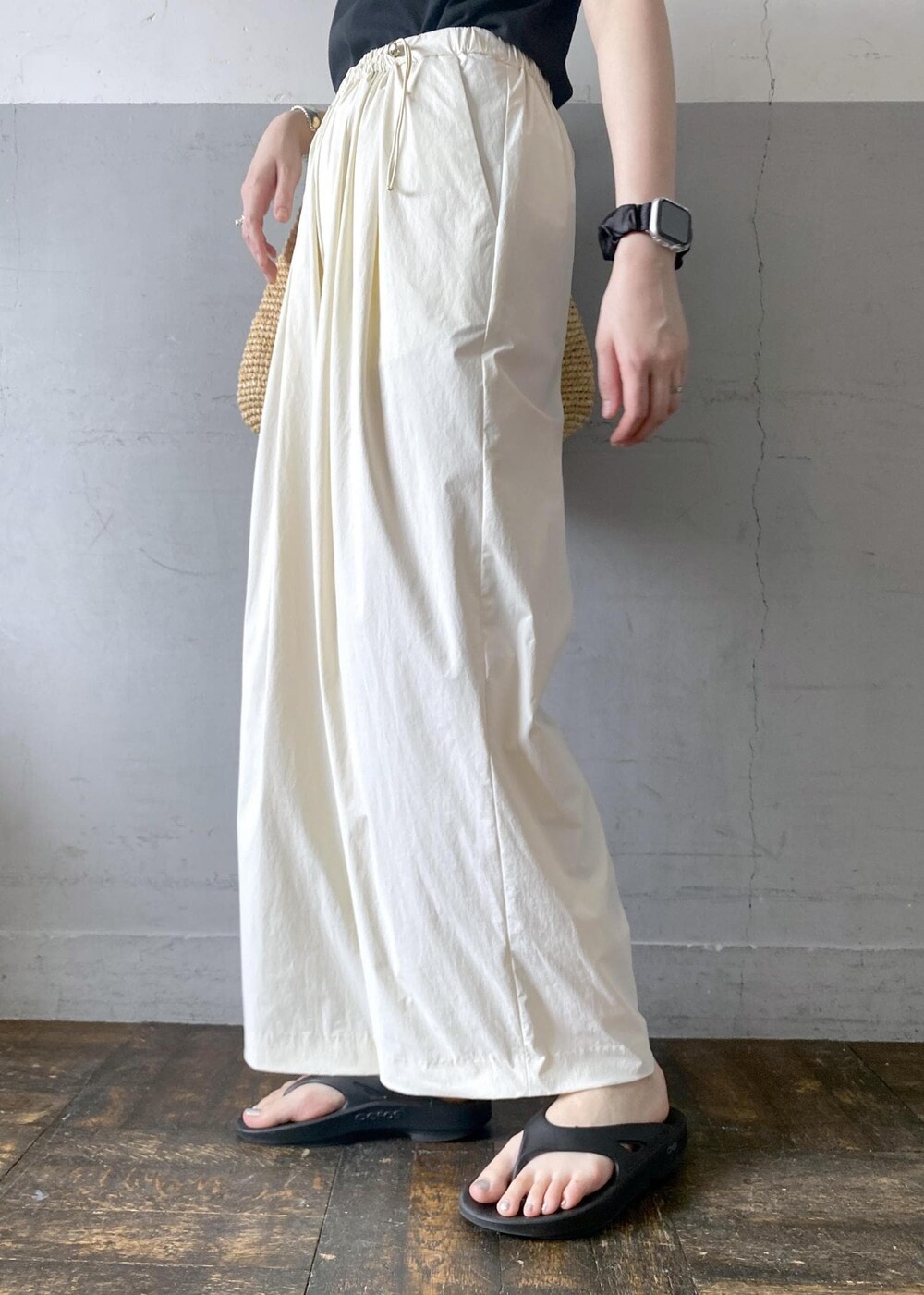 ベージュ系のトートバッグ、ブラック系のTシャツ/カットソー、ブラック系のサンダルを着用したレディースの夏コーディネートの8枚目の写真