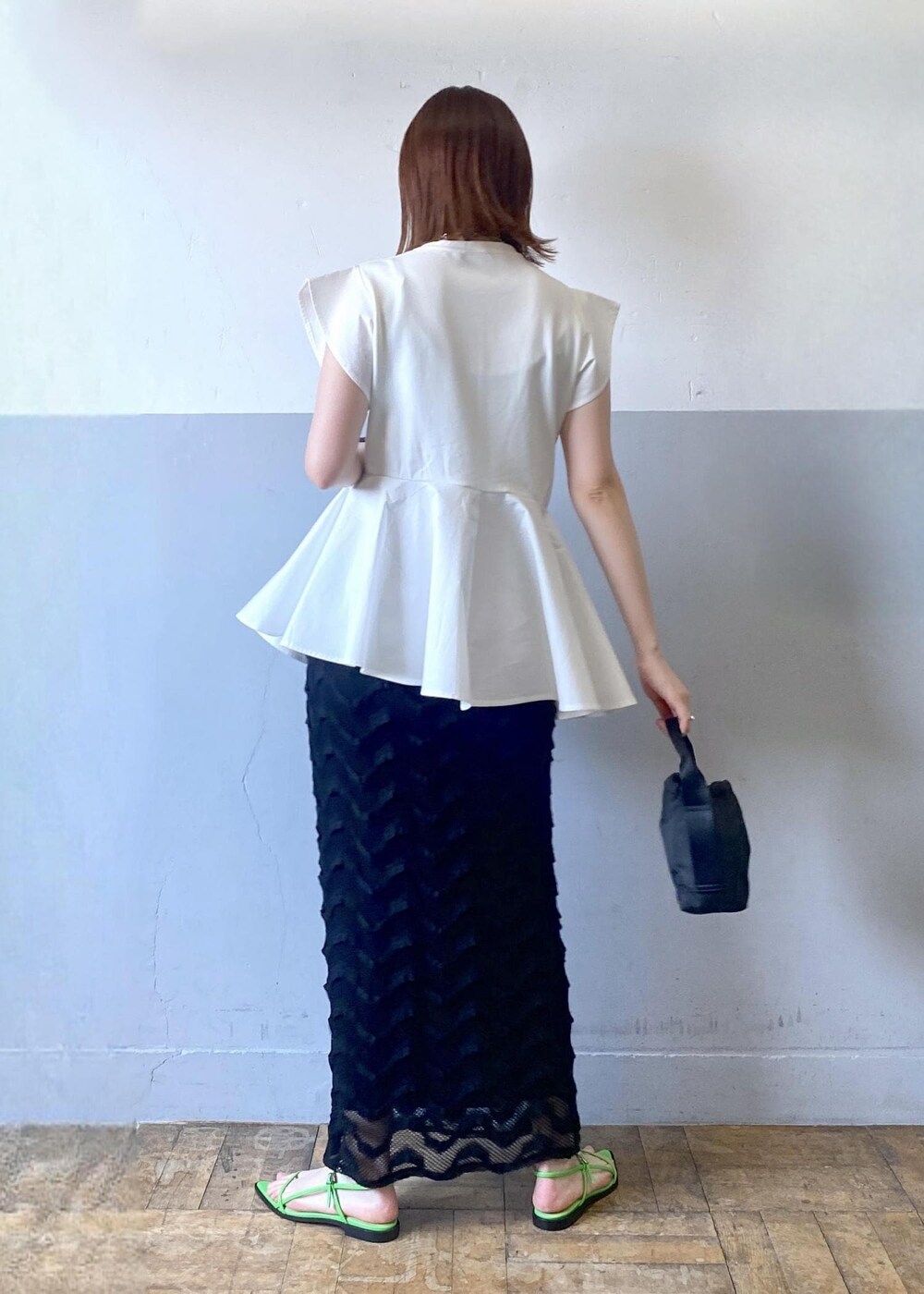 ブラック系のハンドバッグ、グリーン系のサンダル、ブラック系のスカートを着用したレディースの春コーディネートの3枚目の写真