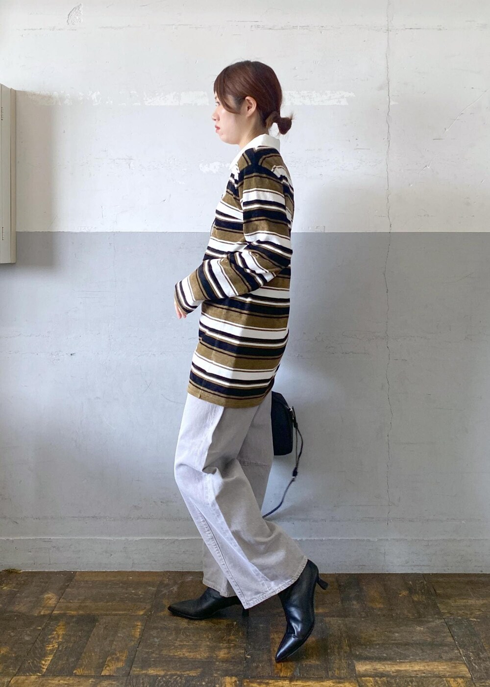 ブラック系のブーツ、ブラック系のボストンバッグ、グリーン系のワンピースを着用したレディースの秋コーディネートの4枚目の写真