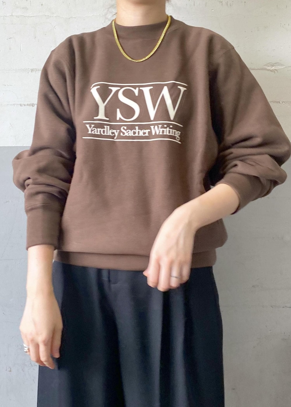 ホワイト系のパンプス、ブラック系のスラックス、ブラック系のボストンバッグを着用したレディースの秋コーディネートの7枚目の写真