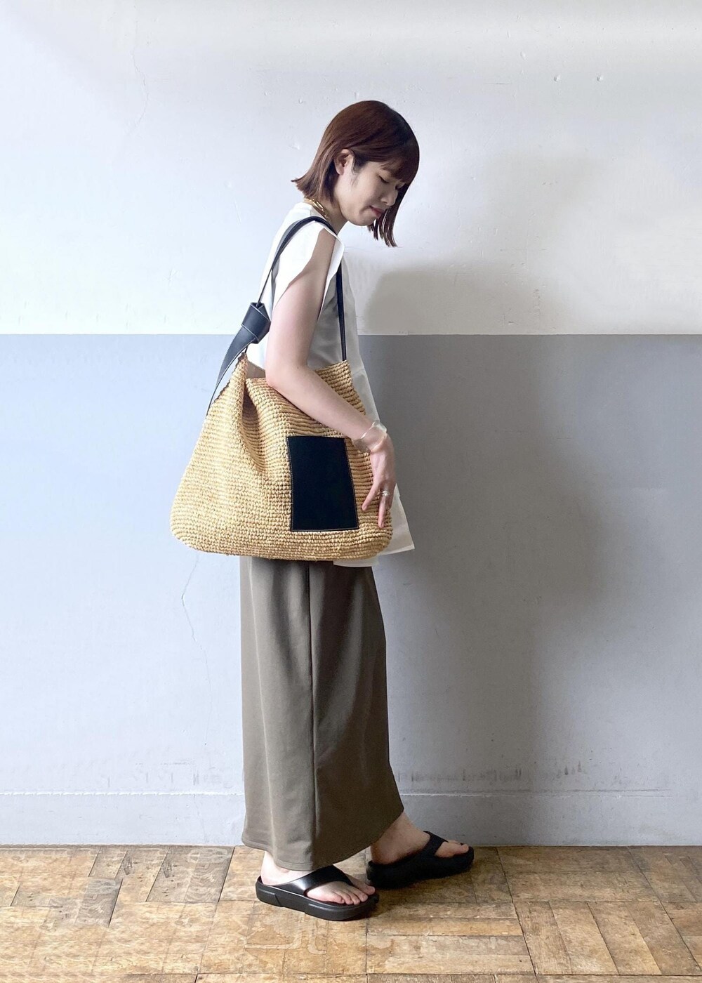 ベージュ系のトートバッグ、グリーン系のワンピース、ホワイト系のTシャツ/カットソーを着用したレディースの夏コーディネートの4枚目の写真