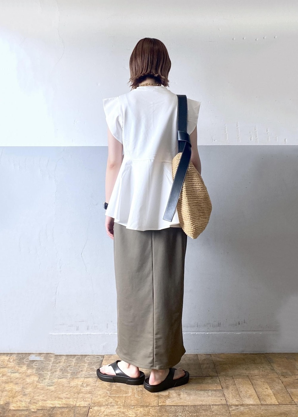 ベージュ系のトートバッグ、グリーン系のワンピース、ホワイト系のTシャツ/カットソーを着用したレディースの夏コーディネートの3枚目の写真