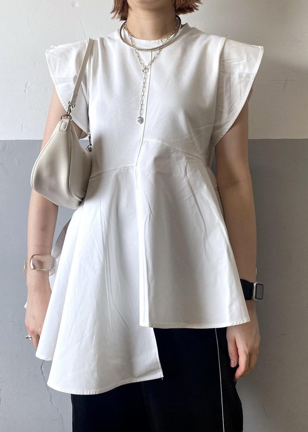 ホワイト系のショルダーバッグ、ブラック系のその他パンツ、ホワイト系のTシャツ/カットソーを着用したレディースの夏コーディネートの6枚目の写真