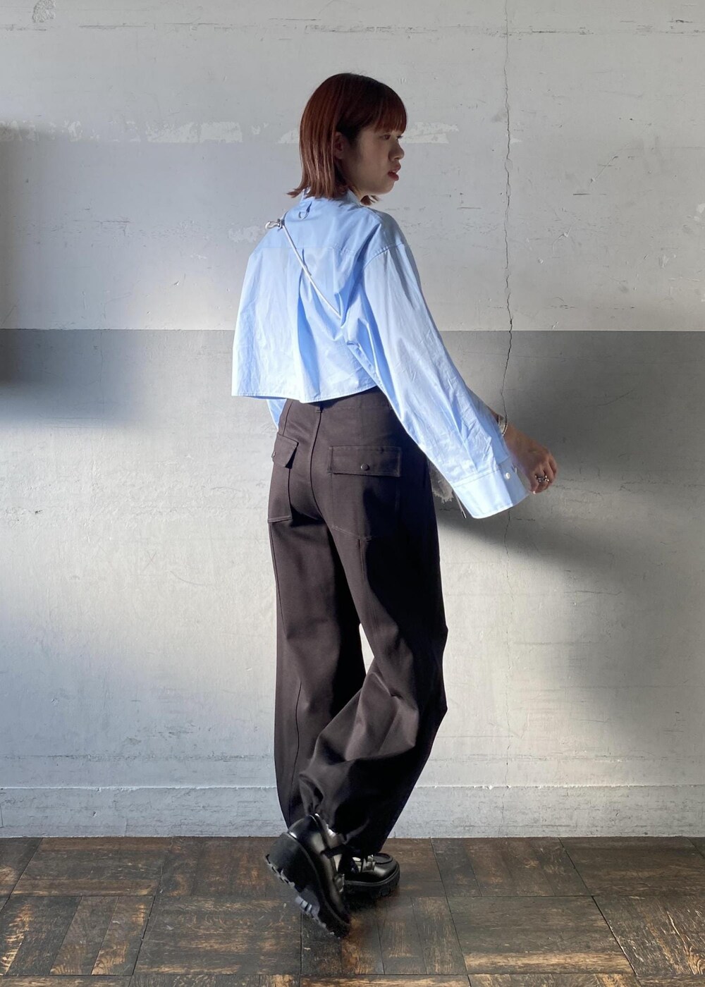 ブラック系のレインシューズ、ブラック系のその他パンツ、ホワイト系のショルダーバッグを着用したレディースの秋コーディネートの4枚目の写真