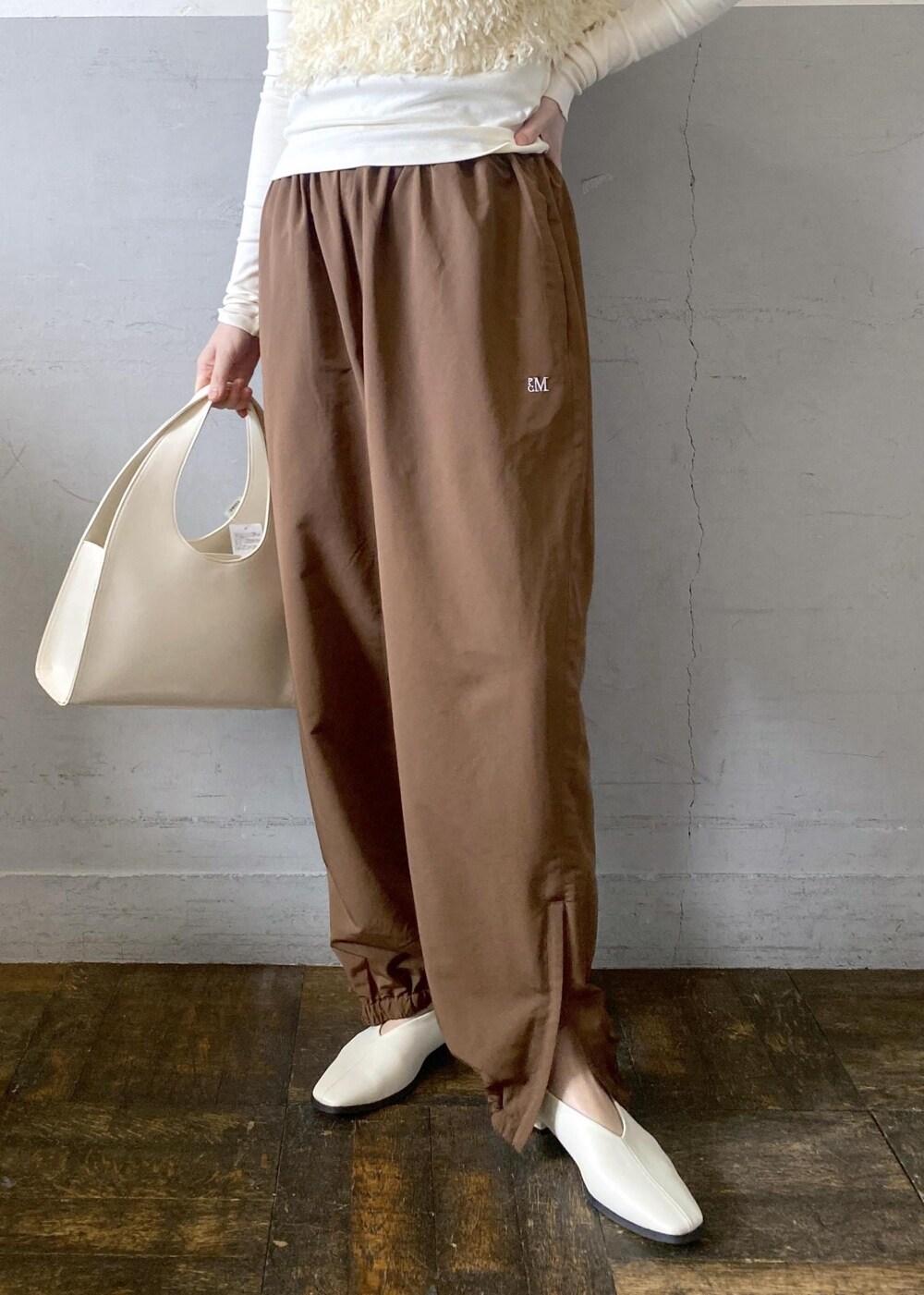 ホワイト系のハンドバッグを着用したレディースの冬コーディネートの10枚目の写真