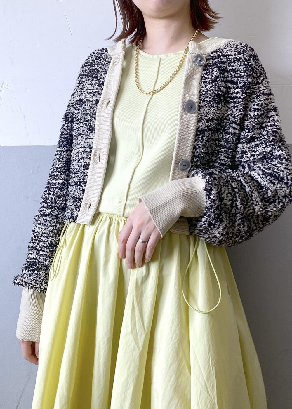 ブラック系のパンプス、ブラック系のショルダーバッグ、ベージュ系のカーディガン/ボレロを着用したレディースの春コーディネートの7枚目の写真