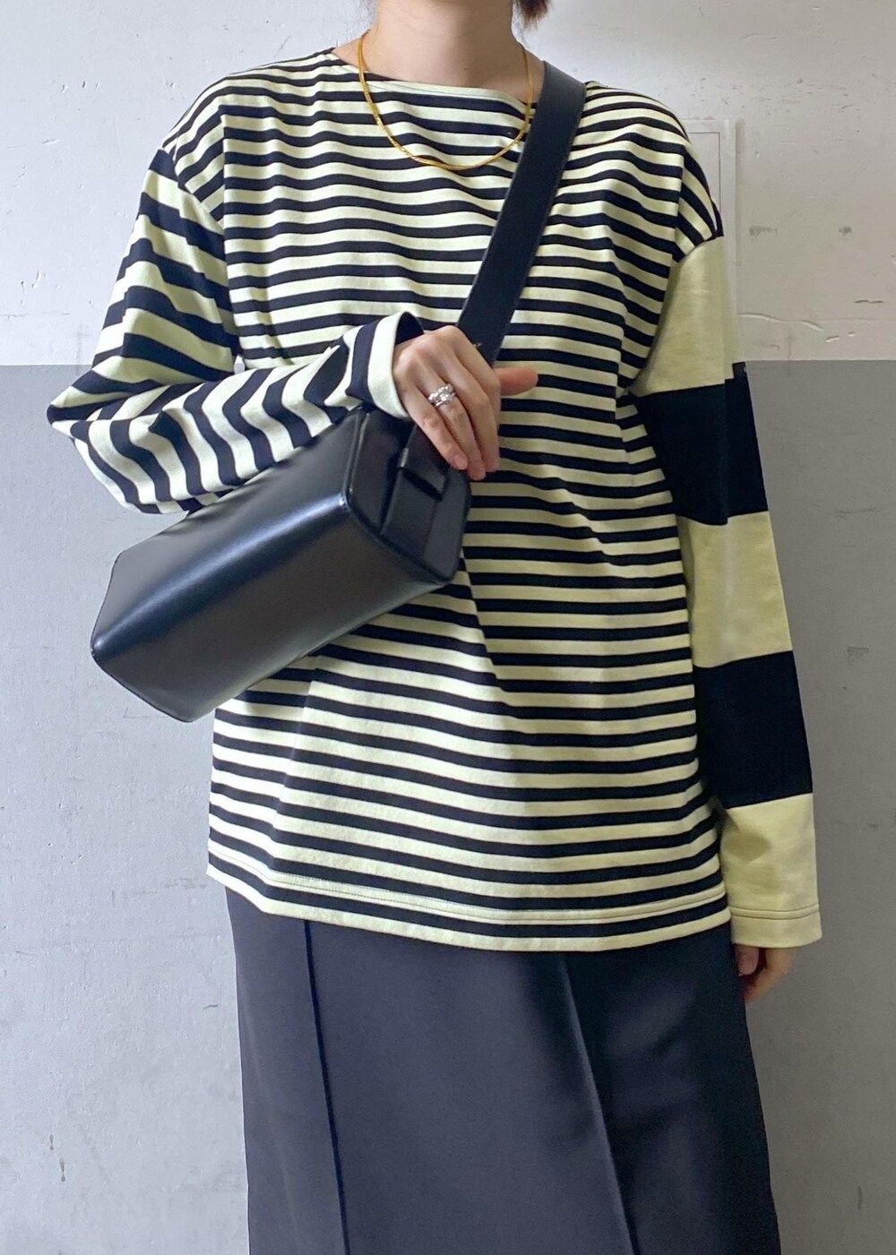 ブラック系のハンドバッグ、ブラック系のローファー、グリーン系のTシャツ/カットソーを着用したレディースの冬コーディネートの9枚目の写真