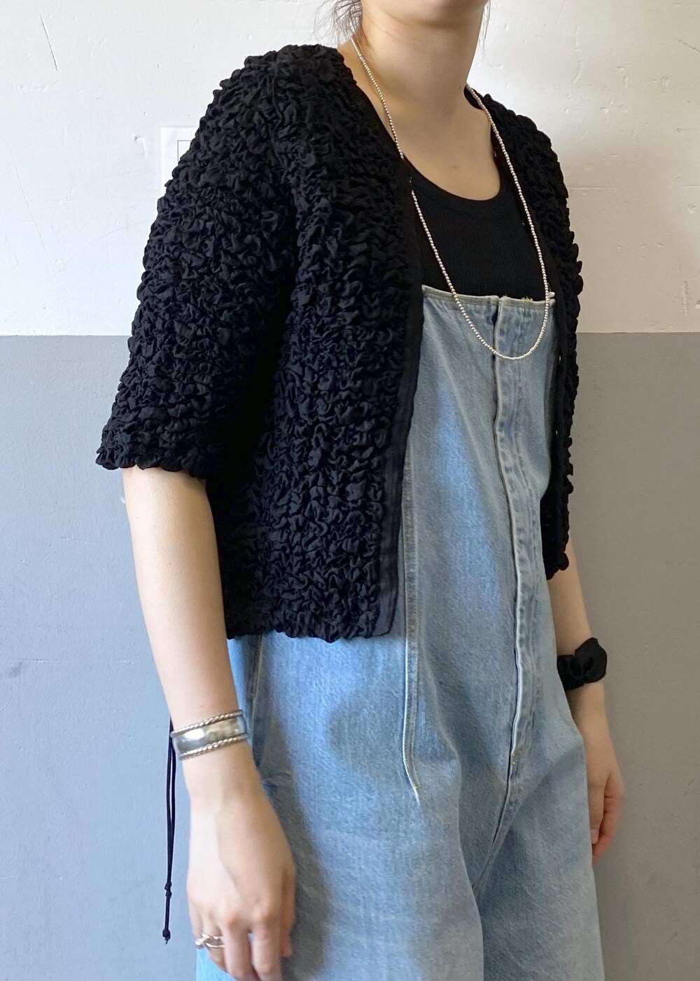 シルバー系のサンダル、ブルー系のサロペット/オーバーオール、ブラック系のカーディガン/ボレロを着用したレディースの春コーディネートの8枚目の写真